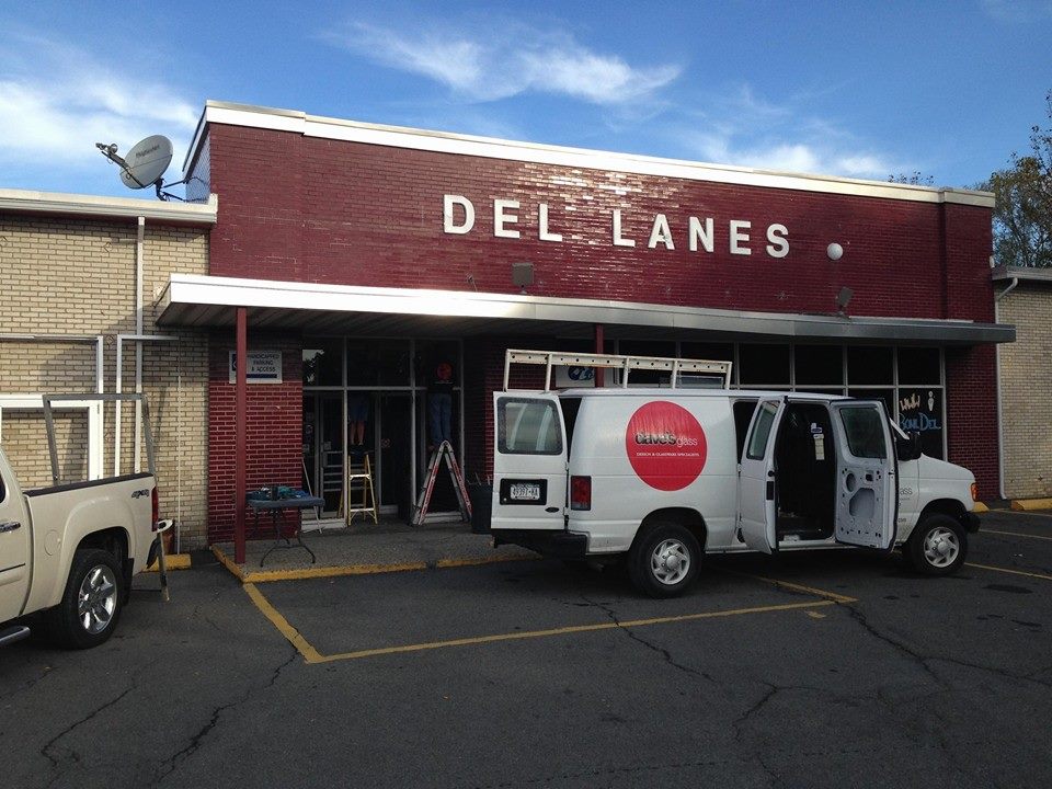 Van from Dave's Glass Co. parked outside of a storefront with a sign reading "DEL LANES"